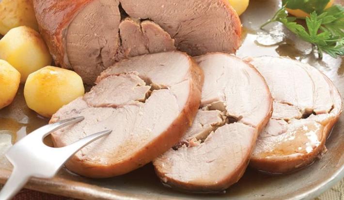 fotografia em tons de marrom e amarelo tirada de pedaços de Pernil de vitela e ao lado batatas