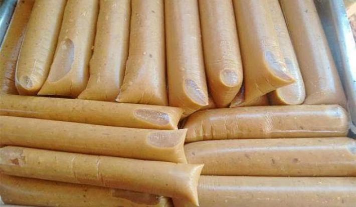 Foto da receita de Geladinho de Coco Queimado. Observa-se uma bandeja com vários saquinhos de geladinho amarronzados.