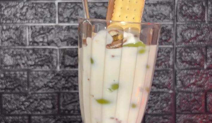Fotografia de uma taça de vidro grande com cmadas de iogurte, choco trio e frutas.