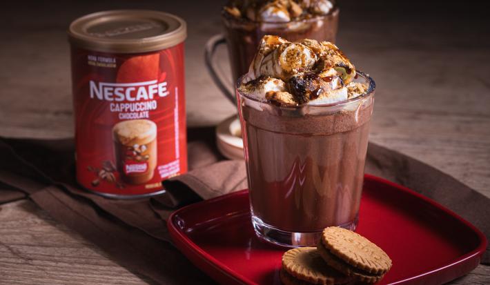 Receita de smorecaccino servida em duas canecas de vidro sobre uma mesa de madeira