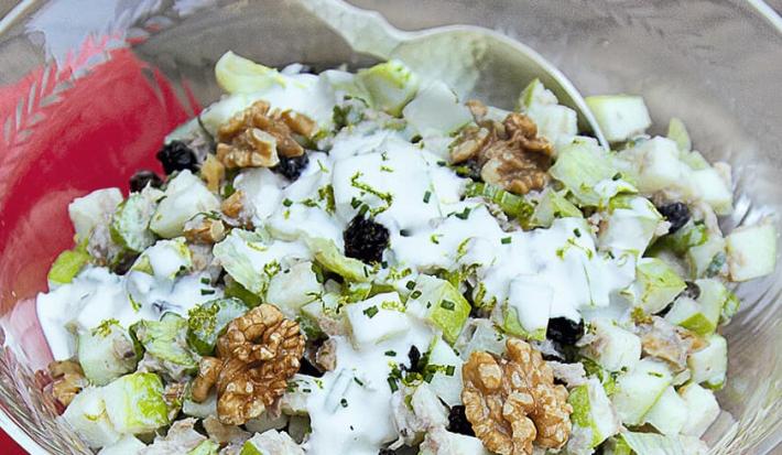 fotografia tirada de cima, contém um pano vermelho e um recipiente redondo de vidro transparente com a salada dentro e creme