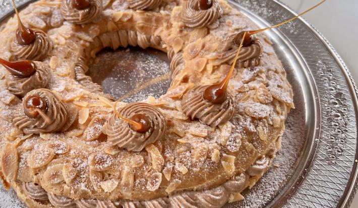 Foto da Receita de Paris Brest com Creme Mousseline, delicioso e impressionante, feito com uma base de massa choux tradicional e um recheio de creme mousseline com pasta de avelã, decorado com açúcar polvilhado e pontos e caramelo