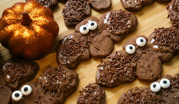 Fotografia de varios biscoitos de chocolates em formato de morcego decorados com granulado.