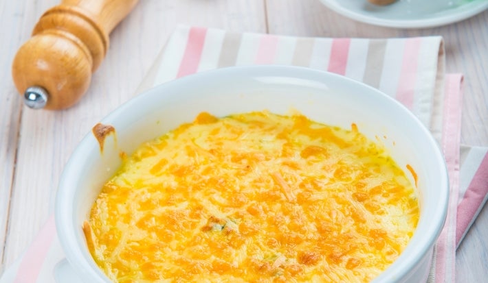 Fotografia em tons de branco com um gratinado ao centro. O gratinado é feito com Brócolis e NINHO Adulto