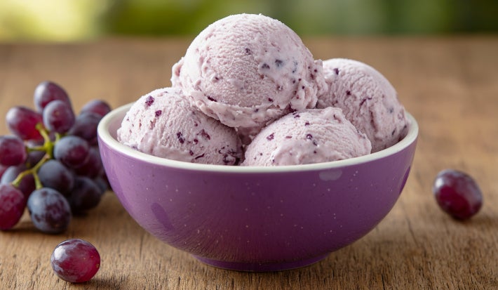 Fotografia de um sorvete de uva caseiro servido em um pote roxo