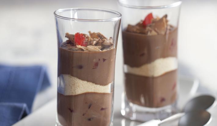 fotografia em tons de cinza e marrom, contém dois copinhos transparentes com creme de chocolate e biscoitos de maisena