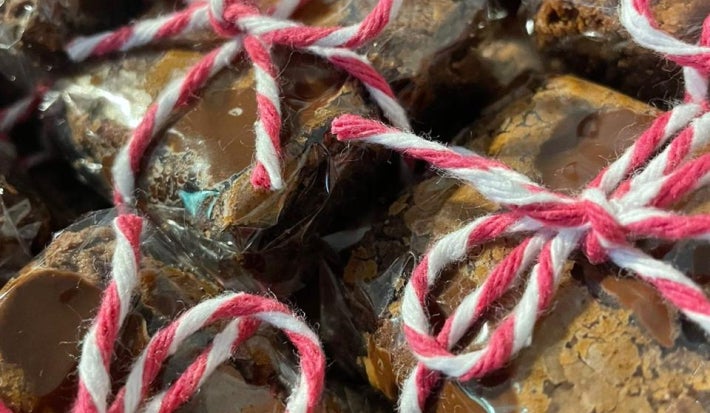 Brownies embalados em plástico transparente, amarrados com barbante rosa e branco, com recheio aparente.