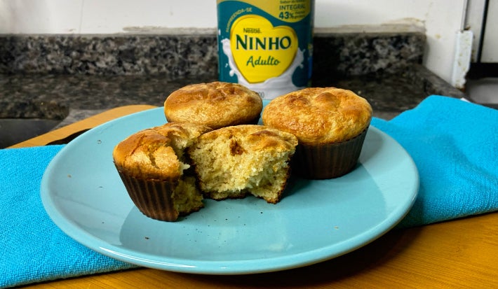imagem mostra uma cesta cheia de bolinhos em tons dourados e pedaços de coco ralado
