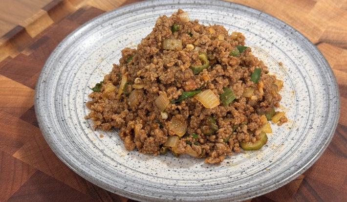 imagem mostra um prato com carne moída e pedaços de quiabo espalhados