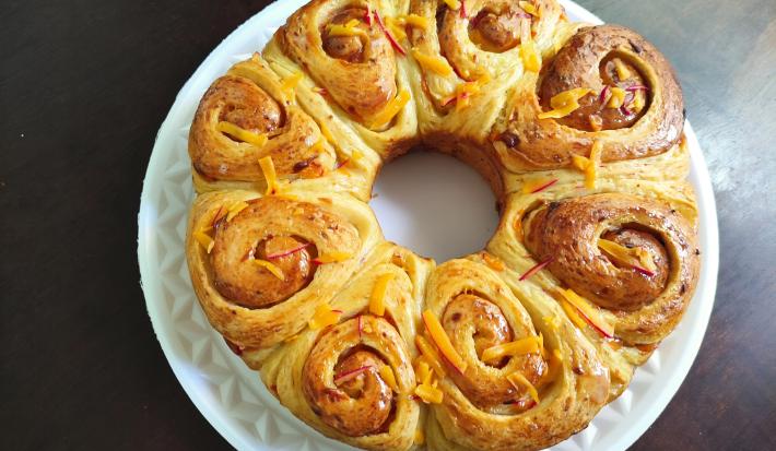 Foto da Receita de Pão de Rosas. Observa-se um pão com formato de rosas brilhante.