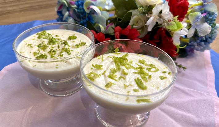 Fotografia em tons de rosa e azul com duas taças de vidro ao centro. Dentro da taça existe uma receita de mousse de limão com ASCENDA.