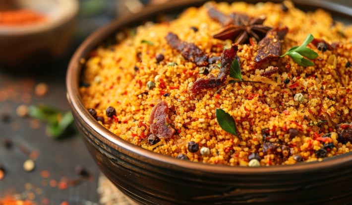 imagem mostra uma travessa com uma farofa com bastante carne seca desfiada e folhas de coentro