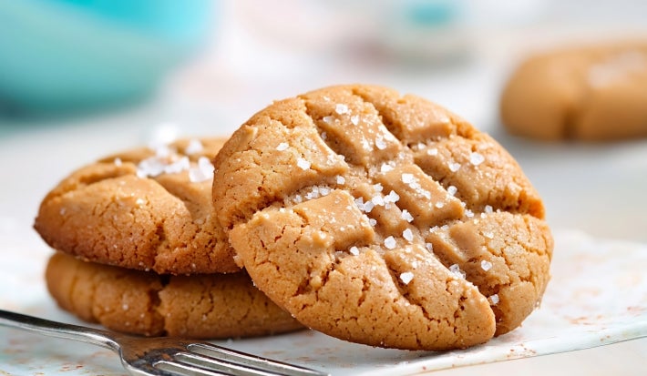 Em cima de uma mesa, prato redondo com biscoitos redondos e crocantes.