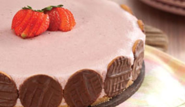 fotografia em tons de rosa e marrom tirada de uma torta de morango com biscoitos de chocolates em volta