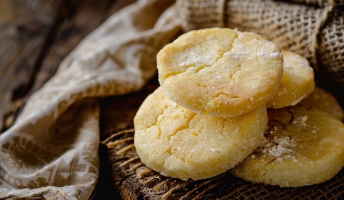 Em cima de uma mesa, prato com biscoitos dourados e crocantes.