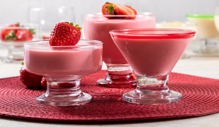 Receita de Nuvem de Morango, fácil e deliciosa, feita com NESTLÉ Creme de Leite, Leite MOÇA, Leite Líquido NINHO Forti+ Integral, coco ralado, Leite NINHO em Pó Integral e morangos frescos, servido em taças com morangos decorando
