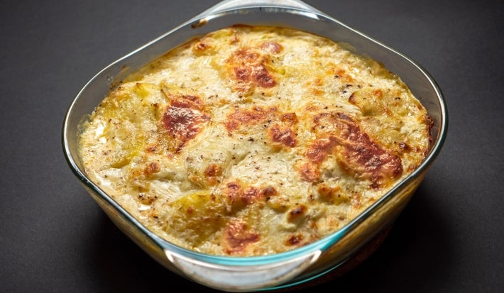 Visto de cima, refratário de vidro transparente com queijo gratinado.