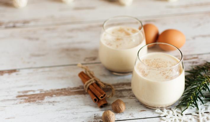 Receita de Gemada Clássica de Natal e Ano Novo, tradicional e deliciosa, feita com ovos, fava de baunilha, NESTLÉ Creme de Leite, Leite Líquido NINHO Forti+ Integral, conhaque e canela, servido em copinhos numa bancada de madeira