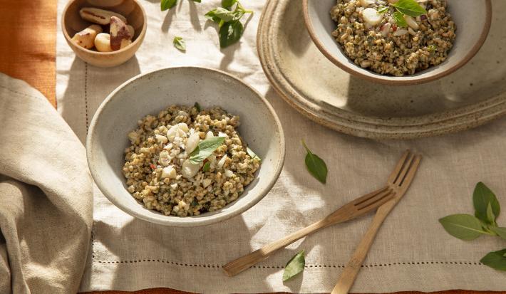 Foto da receita de aveia corte rústico ao pesto servida em duas porções em bowls de cerâmica sobre uma mesa decora com linho