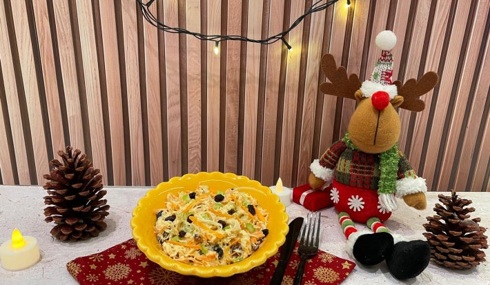 Fotografia em tons de amarelo e natal com um bowl amarelo ao centro e salada de salpicão dentro.