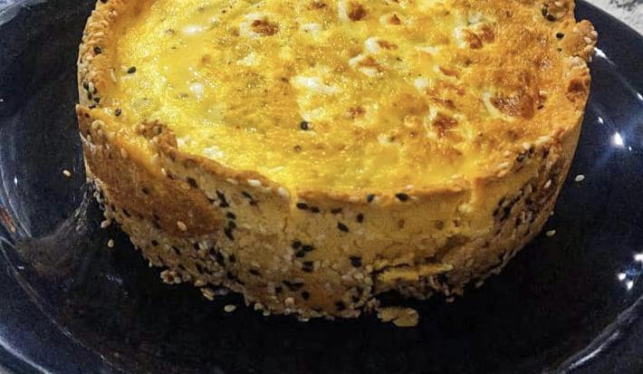 Imagem da receita de Quiche de alho poró nutritiva, em um prato preto, sobre uma mesa