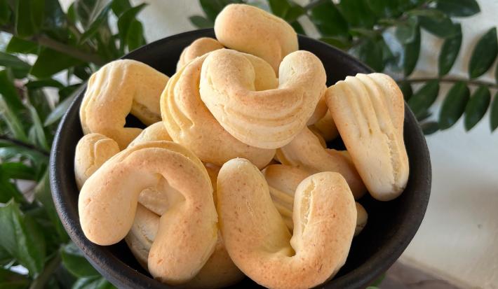 Fotografia de biscoitos de queijo assados em um recipiente preto fundo e médio.