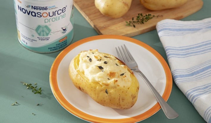 Fotografia batata dourada ao forno, aberta no topo e recheada com creme claro e cremoso, com textura macia e superfície suavemente gratinada. Fotografia batata dourada ao forno, aberta no topo e recheada com creme claro e cremoso, com textura macia e superfície suavemente gratinada.