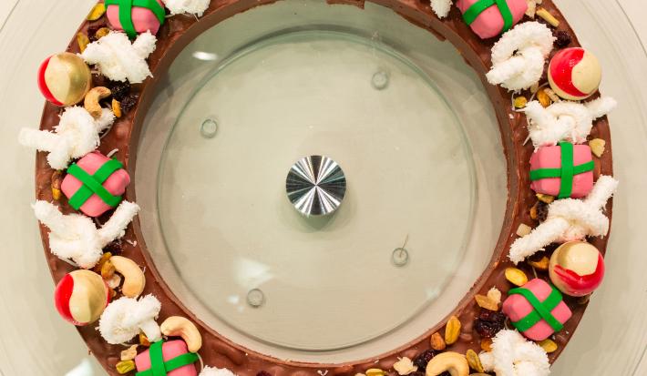 Foto da Receita de Guirlanda de Chocolate diferente e deliciosa feita com uma base de chocolate, bolas de natal bombons, laço de marshmallow e bombons fudge presentes de natal