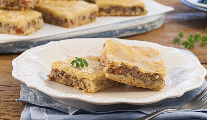 Foto de um prato branco com dois pedaços de torta de carne moída dentro.