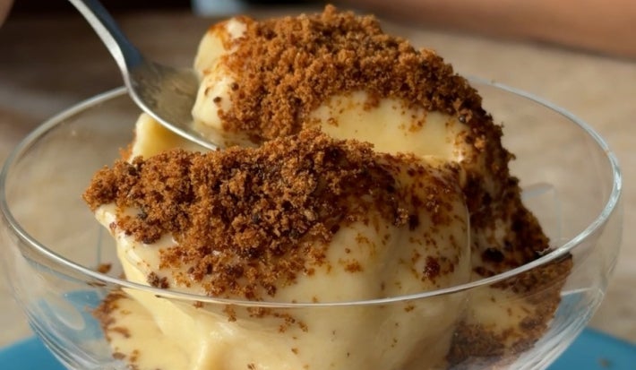 Fotografia de um pote de vidro com sorvete de banana dentro e polvilhado com raspas de chocolate.