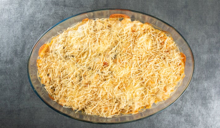 Fotografia em tons de cinza com uma travessa de vidro ao cento. Dentro da travessa existe uma receita de fricassê vegetariano feita com legumes e batata palha. Fotografia em tons de cinza com uma travessa de vidro ao cento. Dentro da travessa existe uma receita de fricassê vegetariano feita com legumes e batata palha.