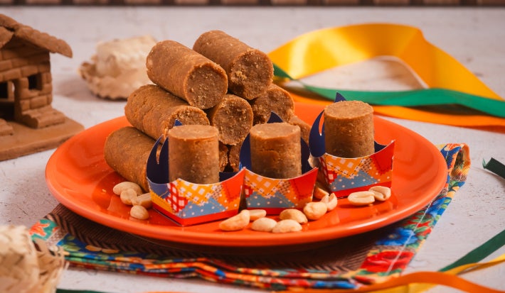 Paçoca de amendoim caseira em formato de rolinhos na festa junina, com amendoins e forminhas coloridas