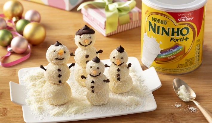 Fotografia em tons claros com vários bonecos de neve feitos com brigadeiro de NINHO Fotografia em tons claros com vários bonecos de neve feitos com brigadeiro de NINHO