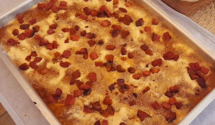 Foto da receita de Polenta com Bacon. Observa-se um recipiente refratário retangular com a preparação.