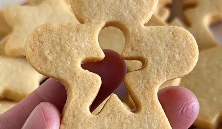 Fotografia em tons de branco com biscoitinhos natalinos em formato de bonequinhos, estrelinha e coração.