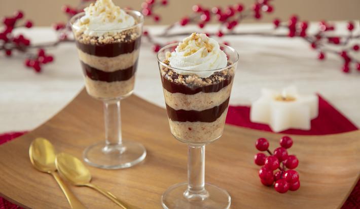 Fotografia de taças individuais mostrano camadas de creme de paçoca, chocolate e no topo chantilly com pedaços de paçoca triturado.