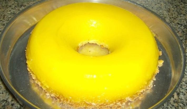 Fotografia de uma receita de quindim grande dentro de uma forma meio funda prata.