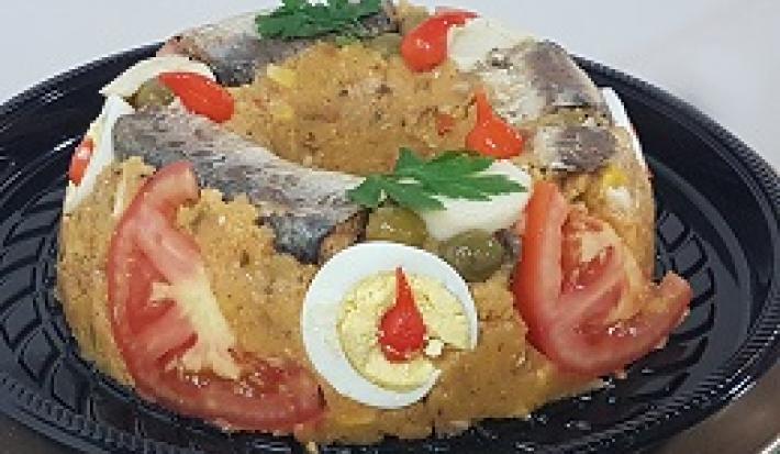 Foto da receita de Cuscuz Paulista Maravilhoso. Observa-se um cuscuz decorado com tomate, ovos, sardinha.