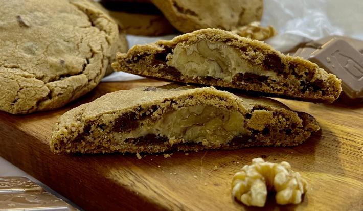 Foto da receita de Cookies recheados de nozes. Na foto observa-se cookies dispostos sobre uma tábua de madeira.