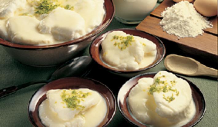 em quatro recipientes contém os Ovos Nevados. Ao lado uma tabua com quatro ovos, farinha e uma jarra de leite