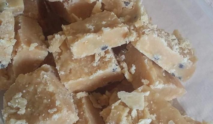 Foto da receita de Cocada de Maracujá do Tio. Observa-se algumas cocadinhas retangulares com as sementes do maracujá.