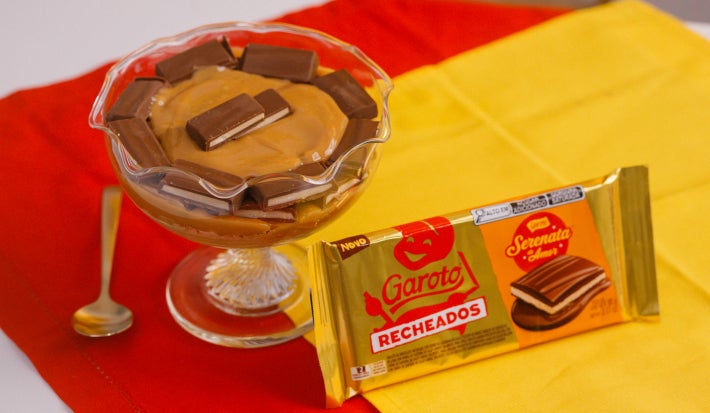 Pavê em taça de vidro com camadas de creme e pedaços de chocolate Serenata do Amor Recheado.