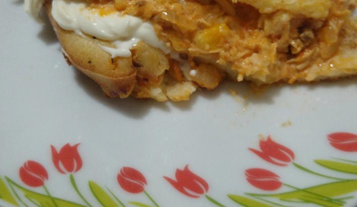 Fotografia de um pedaço de torta de frango com requeijão sobre um prato branco com desenhos.