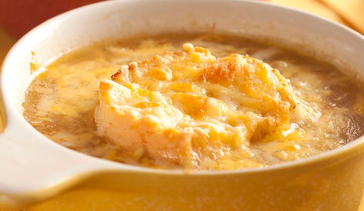 Fotografia em tons de branco e amarelo de uma bancada amarela vista de cima, uma panela redonda amarela com alças brancas contém a sopa cremosa Fotografia em tons de branco e amarelo de uma bancada amarela vista de cima, uma panela redonda amarela com alças brancas contém a sopa cremosa
