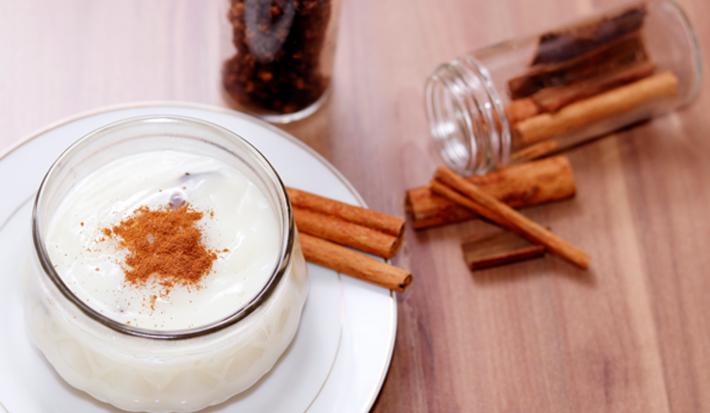 Foto da receita de Mingau de Amido Tradicional. Observa-se um mingau num potinho de vidro polvilhado de canela.