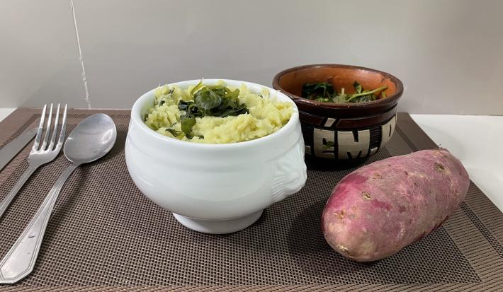Receita de Purê de Batata Doce com Jambú em um recipiente branco, ao lado uma batata doce e garfo e colher
