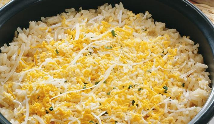 Uma panela comporta o arroz em tons amarelos.