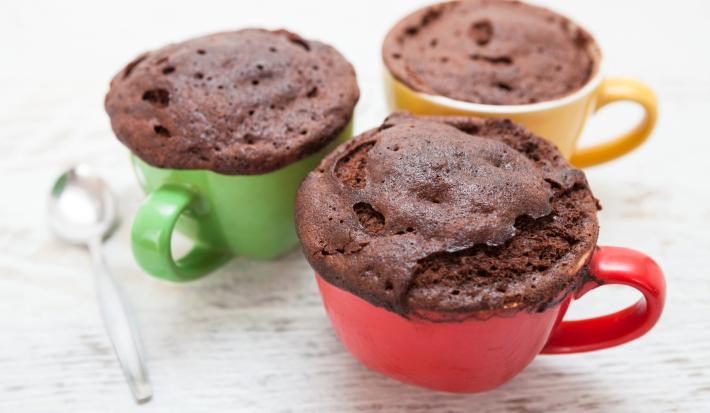Imagem de uma caneca vermelha, verde e amarela com a receita do bolo de Nescau.