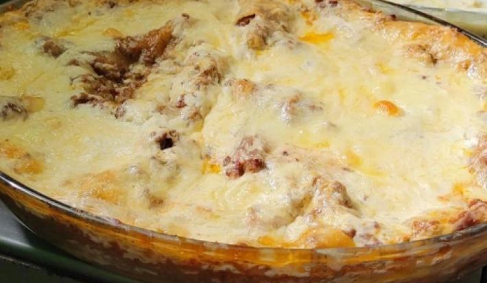 Receita em tons de amarelo da receita de lasanha para conquistar a sogra servida em uma forma de vidro com queijo gratinado por cima