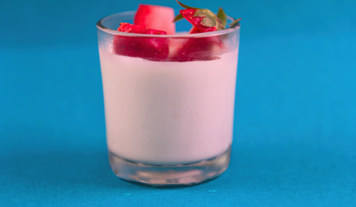 Uma deliciosa mousse de morango com uma textura cremosa e suave, decorada com morangos frescos e servida em copo.